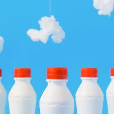 some milkbottles in a row under some clouds